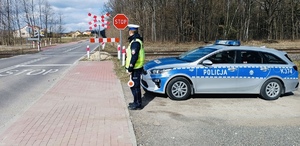 policjant stoi na przejeździe kolejowym