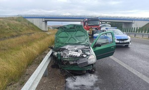 na autostradzie stoi uszkodzony samochód w tle radiowóz i wóz strażacki