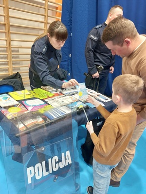 policjantka podaje chłopcu ulotkę