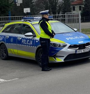 policjantka stoi obok radiowozu przy drodze