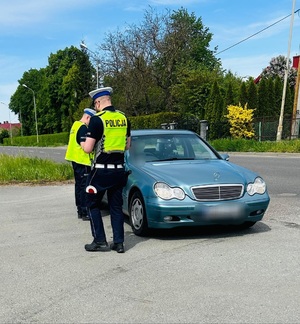 policjanci stoją przy samochodzie osobowym