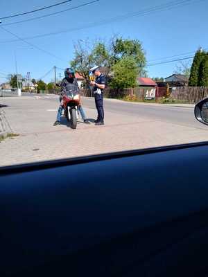 policjant stoi przy motocykliście