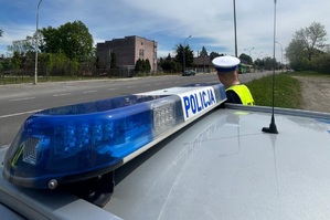 policjant stoi przy radiowozie