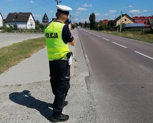 policjant ruchu drogowego prowadzi pomiar prędkości pojazdów