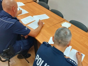 policjanci siedzą przy stole rozwiązują testy