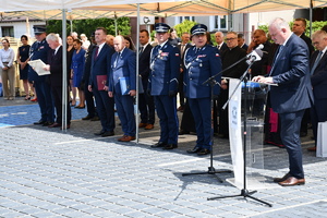 policjanci i pracownicy cywilni stoją pod zadaszeniem