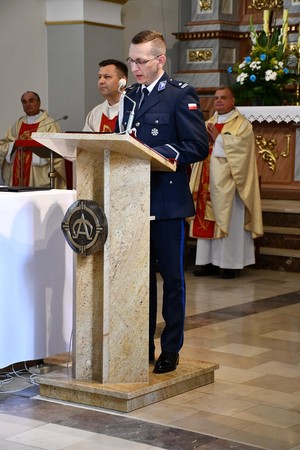 policjant mówi do mikrofonu w kościele