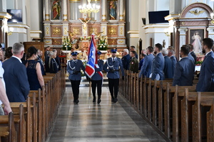 policjanci wychodzą ze sztandarem z kościoła