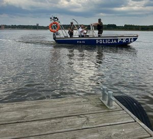 w łodzi na wodzie jest policjant i dwóch funkcjonariuszy państwowej strazy rybackiej