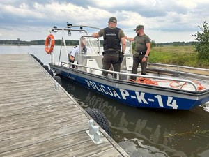 na wodzie w łodzi są funkcjonariusze państwowej straży rybackiej oraz policjanci