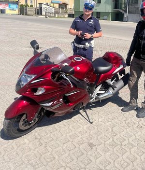 policjant stoi przy motocyklu