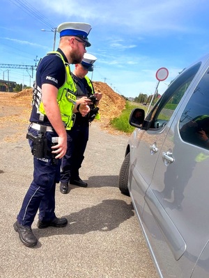 policjanci prowadza kontrolę pojazdu