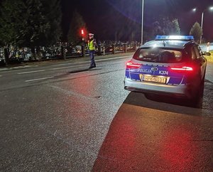 policjant zatrzymuje pojazd do kontroli w porze nocnej