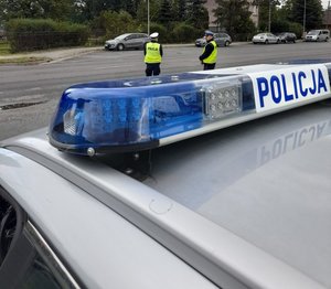 policjanci ruchu drogowego stoją przy drodze