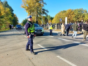 policjanci stoją na drodze przez jezdnię przechodzą osoby