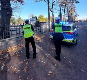 policjanci stoją przed cmentarzem