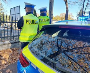 policjanci stoją przy cmentarzu