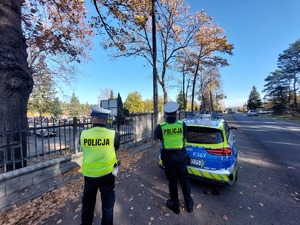 policjanci stoją przy cmentarzu