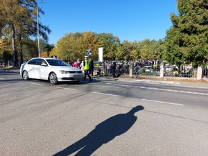 policjanci kierują ruchem na jezdni po której chodzą piesi i jadą pojazdy