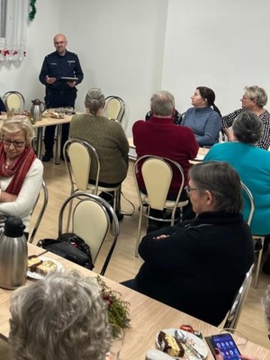 policjant stoi przed grupą seniorów