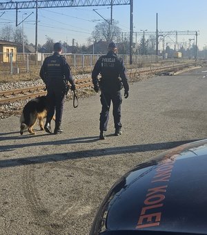 funkcjonariusz policji i służby ochrony kolei idą wzdłuż torów kolejowych, fot. kpp nisko