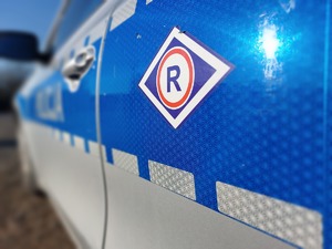 bok policyjnego radiowozu z widocznym emblematem w kształcie rombu &quot;R&quot;