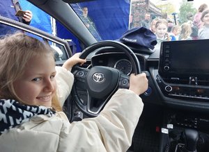 dziewczynka siedzi za kierownicą policyjnego radiowozu