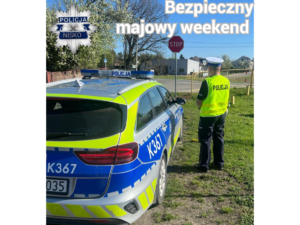 policjant kontrolujący ruch przy drodze obok radiowozu napis bezpieczny majowy weekend oraz policyjna gwiazda z napisem nisko policja