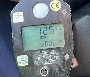 policyjne urządzenie do pomiaru prędkości pojazdów z wyświetloną wartością 124