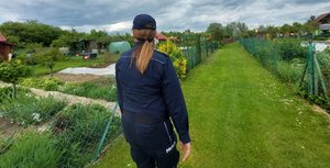 policjantka podczas obchodu terenu ogródków działkowych