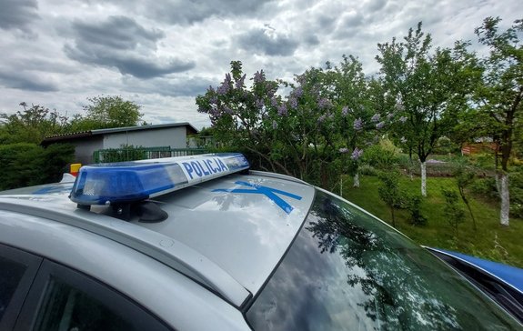 policyjny radiowóz przed terenem ogródków działkowych