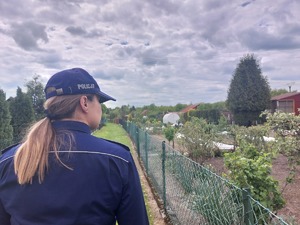 policjantka podczas obchodu terenu ogródków działkowych
