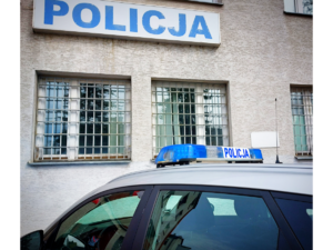 policyjny radiowóz widok z góry dachu i policyjnej belki z napisem policja zaparkowany przed budynkiem z napisem policja