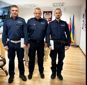 policjanci stoją w rzędzie w gabinecie w rękach trzymają teczki