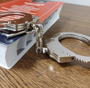 kajdanki leżą na kodeksie karnym