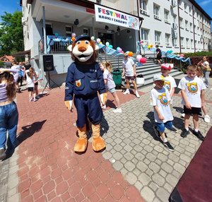 policyjna maskotka lew podczas pikniku dla dzieci na placu przed szkołą