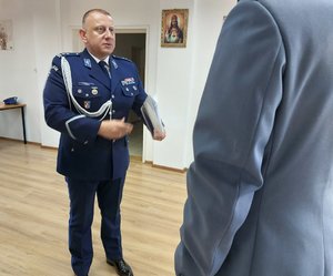 policjant przekazuje teczkę z aktem mianowania drugiemu policjantowi