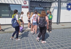 uczniowie stoją przed budynkiem komisariatu policji