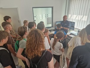 policjant w budynku komisariatu z uczniami