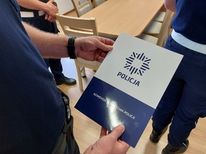 policjant trzyma w ręku teczke z napisem kpp nisko