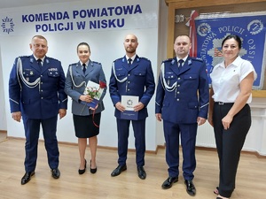 policjanci stoją w rzędzie pod napisem komenda powiatowa policji w nisku z aktami mianowania