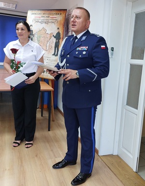 policjant trzyma w rękach teczkę z napisem komenda powiatowa policji w nisku