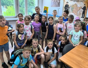 dzieci stoją z policjantką w pomieszczeniu służbowym
