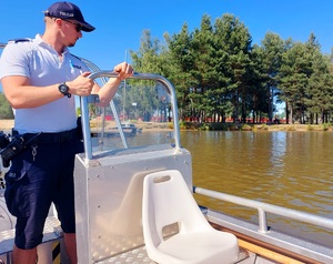 policjanci na łodzi na zbiorniku wodnym patrolują teren zalewu