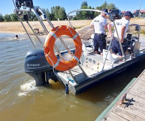 policjanci na łodzi na zbiorniku wodnym patrolują teren zalewu