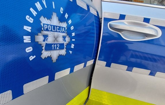 napis na drzwiach policyjnego radiowozu pomagamy i chronimy
