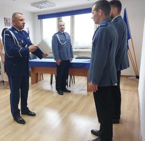 policjanci przekazują sobie akty mianowania