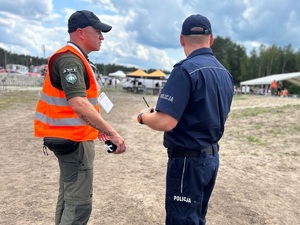 policjant z mężczyzną podczas zabezpieczenie imprezy plenerowej