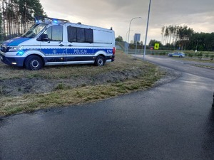 policyjny radiowóz w miejscu zabezpieczenia imprezy plenerowej widok placu i ulicy w tle umundurowani policjanci