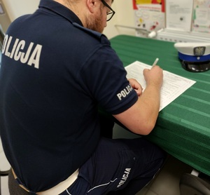 policjant podczas wypełniania karty dot krwiodastwa